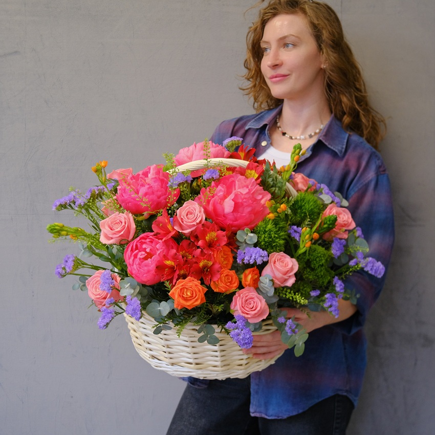 Коралловые пионы и кустовые розы в яркой корзине "Закат над океаном"
