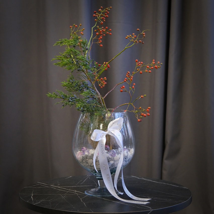 Луковица амариллиса, шиповник и можжевельник в круглой вазе