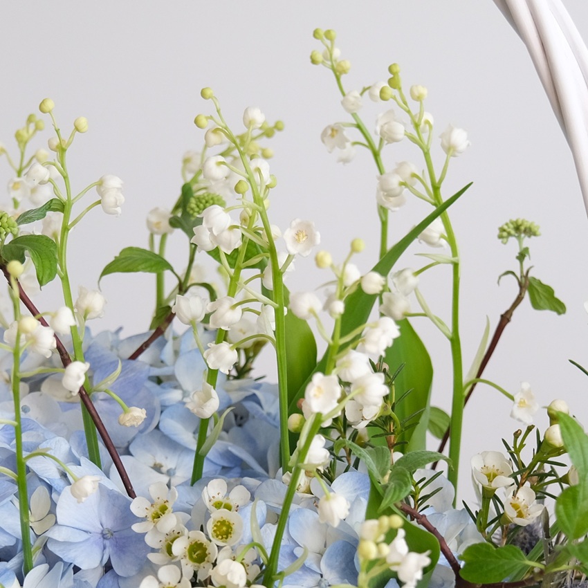 Ландыши и голубая гортензия в корзинке