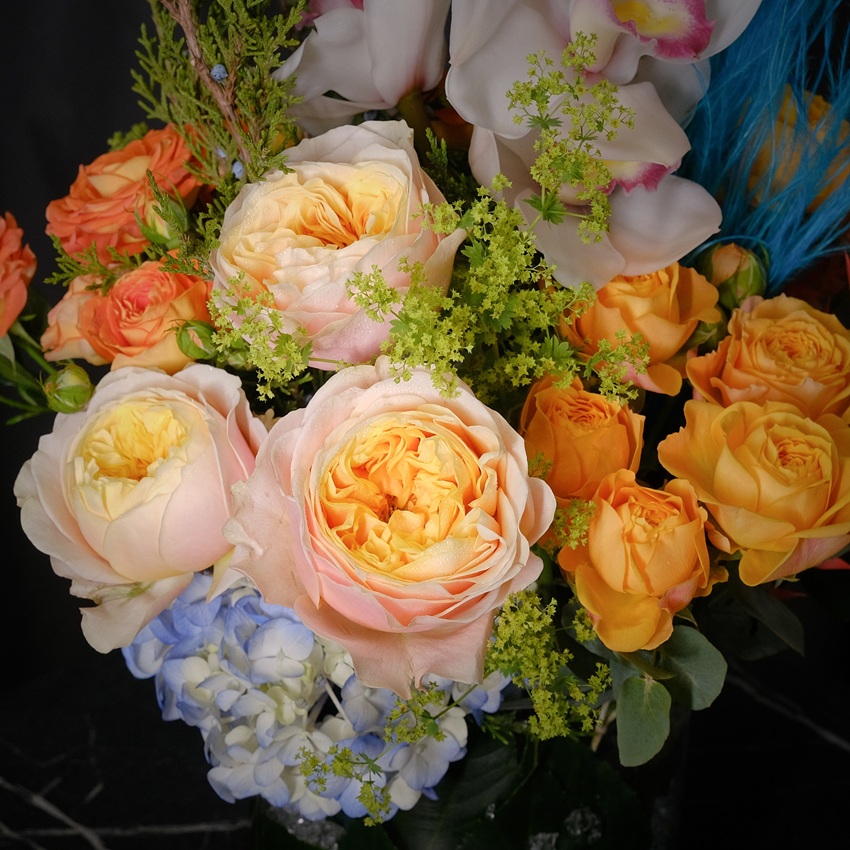 Орхидеи, голубая гортензия и пионовидные розы в стеклянной вазе