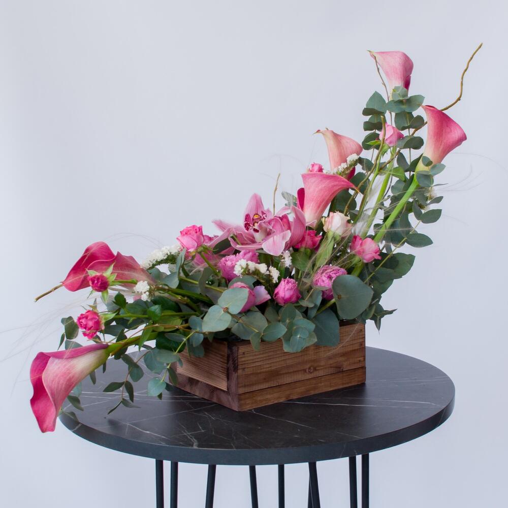 Интерьерная композиция с орхидеями и каллами в деревянном ящике