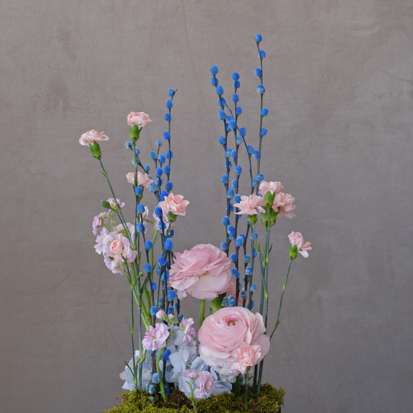  Композиция на Пасху в деревянном ящичке: голубая верба, ранункулюсы и гвоздики 