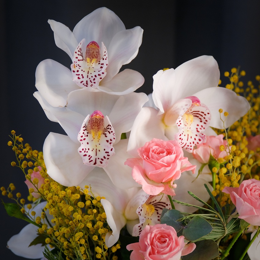 Белая орхидея Цимбидиум и мимоза в стеклянной вазе