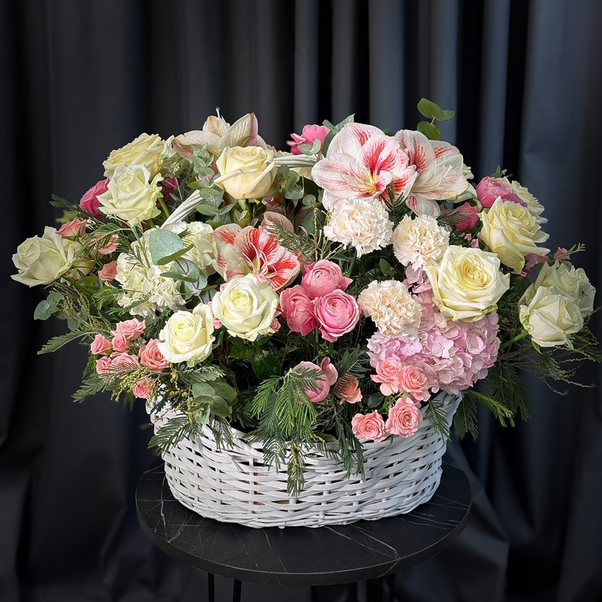Розовые амариллисы и пионовидные розы в большой корзине