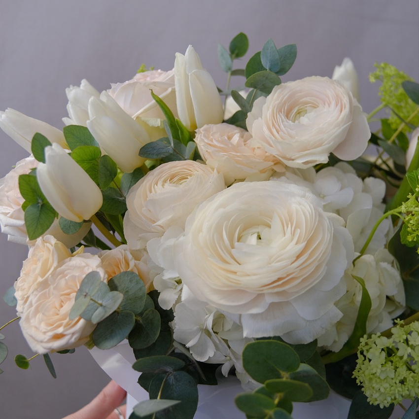 Ранункулюсы, белые тюльпаны и розы Охара в коробке с эвкалиптом