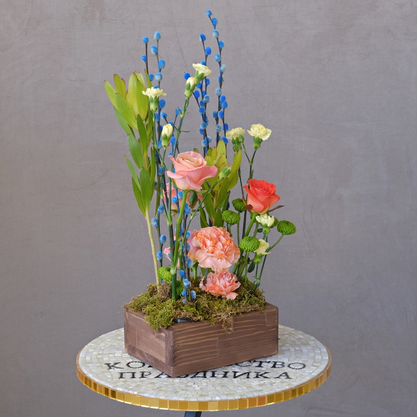 Композиция на Пасху в деревянном ящичке: голубая верба, розы и леукадендрон 