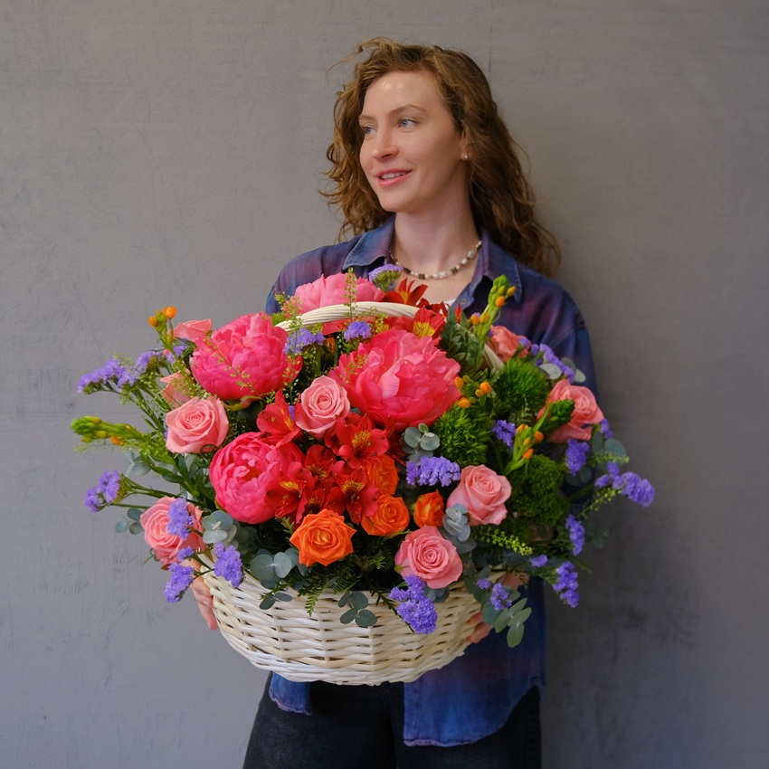 Коралловые пионы и кустовые розы в яркой корзине "Закат над океаном"