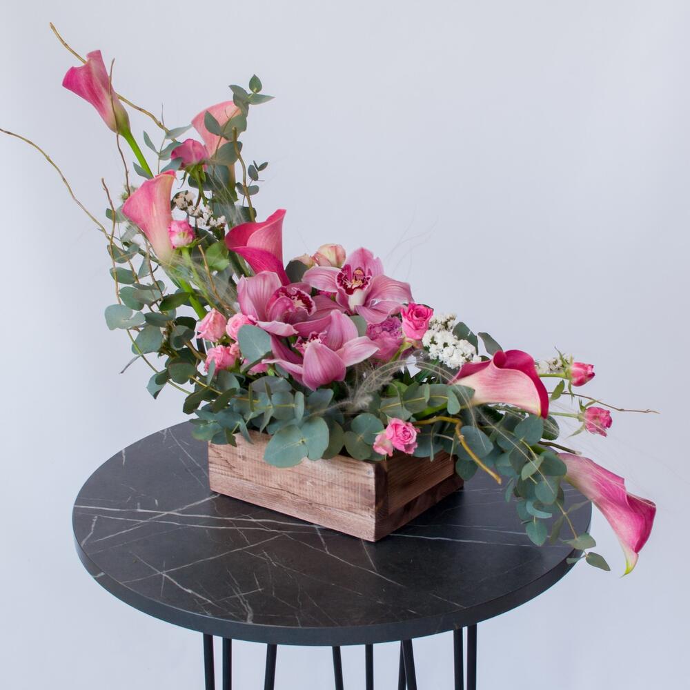 Интерьерная композиция с орхидеями и каллами в деревянном ящике