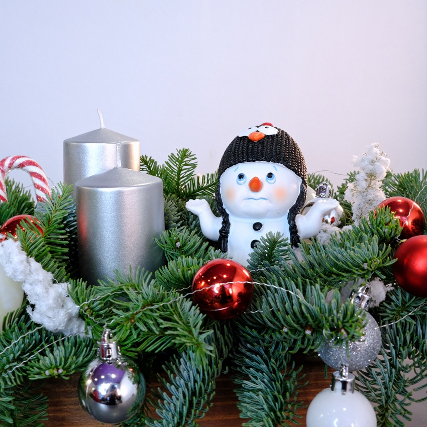 Новогодняя композиция из нобилиса со свечами и сувениром "Очаровательный снеговик"