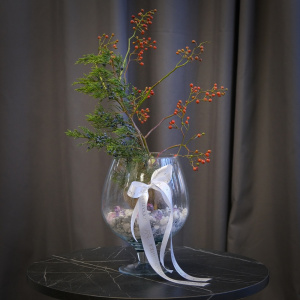 Луковица амариллиса, шиповник и можжевельник в круглой вазе