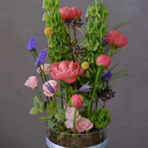 Коралловые пионы и молюцелла в интерьерном букете в вазе "Солнце в стекле"