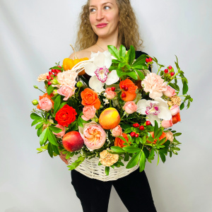 Белые орхидеи и пионовидные розы в осенней корзине с тыковками и фруктами