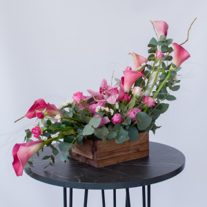 Интерьерная композиция с орхидеями и каллами в деревянном ящике