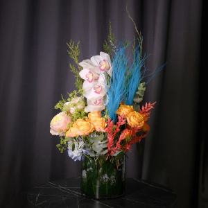 Орхидеи, голубая гортензия и пионовидные розы в стеклянной вазе