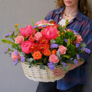 Коралловые пионы и кустовые розы в яркой корзине "Закат над океаном"