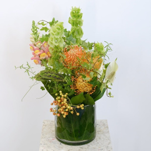 Экзотическая композиция для интерьера в стеклянной вазе: моллюцелла, нутан и антирринум