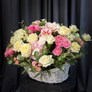 Розовые амариллисы и пионовидные розы в большой корзине