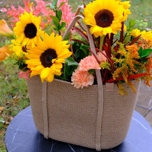 Подсолнухи и каллы в роскошной плетеной сумке