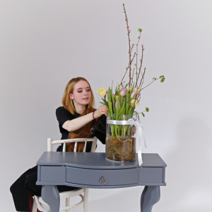 Тюльпаны и ветки сакуры в стеклянной вазе