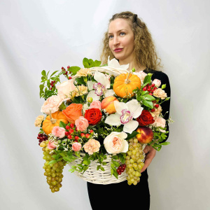 Белые орхидеи и пионовидные розы в осенней корзине с тыковками и фруктами