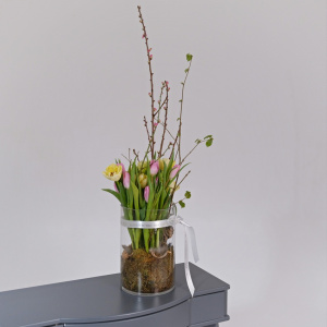 Тюльпаны и ветки сакуры в стеклянной вазе