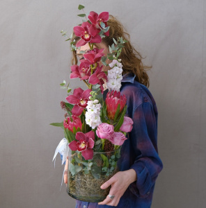 Бордовая орхидея Цимбидиум и протея в стеклянной вазе