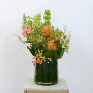 Экзотическая композиция для интерьера в стеклянной вазе: моллюцелла, нутан и антирринум