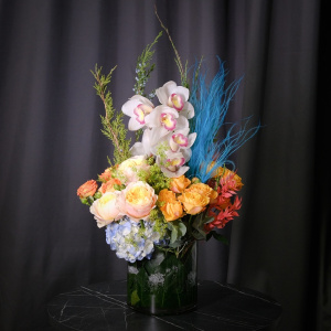 Орхидеи, голубая гортензия и пионовидные розы в стеклянной вазе