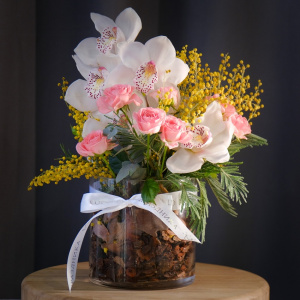 Белая орхидея Цимбидиум и мимоза в стеклянной вазе