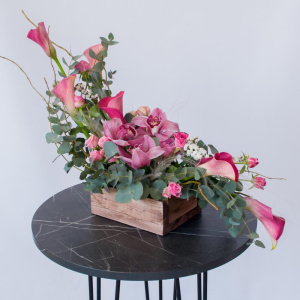 Интерьерная композиция с орхидеями и каллами в деревянном ящике