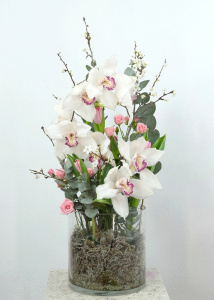 Белая орхидея цимбидиум в стеклянной вазе с эвкалиптом