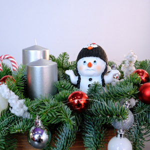 Новогодняя композиция из нобилиса со свечами и сувениром "Очаровательный снеговик"
