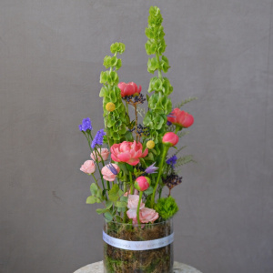 Коралловые пионы и молюцелла в интерьерном букете в вазе "Солнце в стекле"