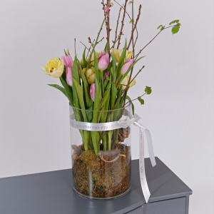 Тюльпаны и ветки сакуры в стеклянной вазе