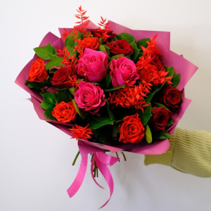 Ароматные красные розы в пышном букете с зеленью